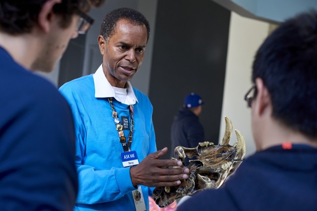 Volunteer holding skull and talking to visitors