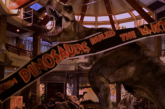 Orange and black banner in front of a dinosaur