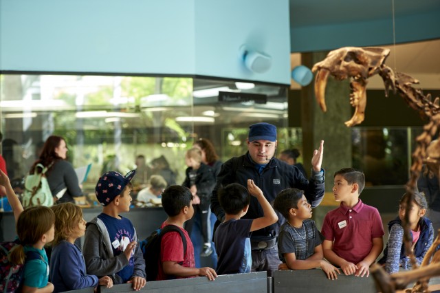 school group next to sabertooth skeleton tar pits field trip