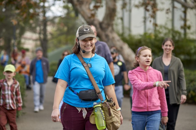 Museum Educator leading a group of visitors walking behind them