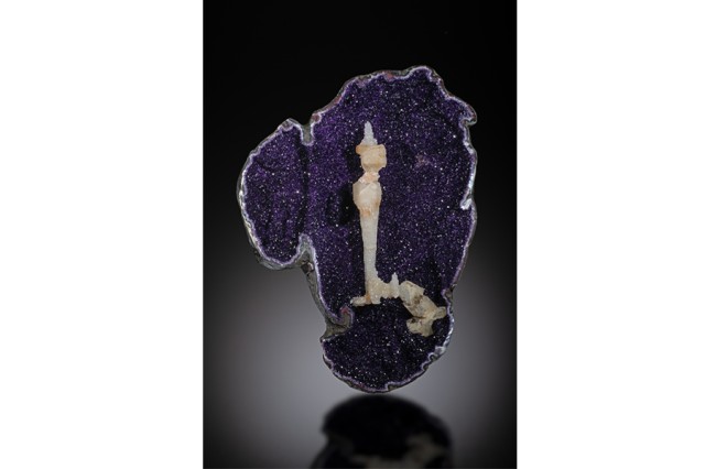 Open half of a purple crystal with a peach stone formation in the center