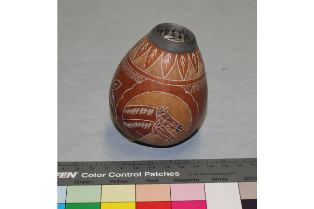 Photo of reddish brown gourd cup that is decorated with a drawing of two horse heads