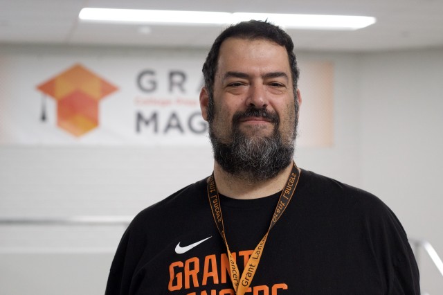 Chris Chavez wearing a black t-shirt with orange lettering and a black and orange lanyard