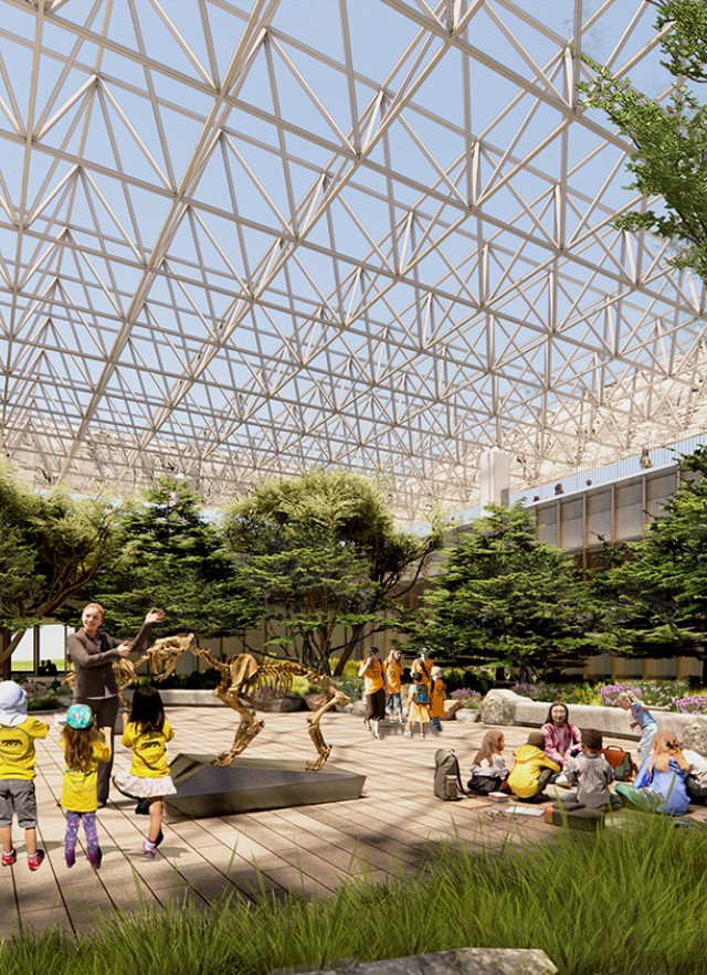 Children in yellow shirts facing a Museum Educator gesturing towards a saber-toothed cat skeleton in an outside courtyard