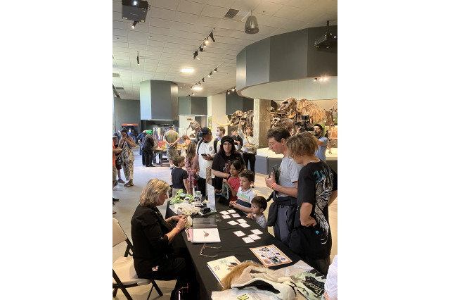 Adults and children standing around a table