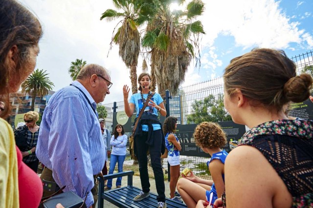 Museum Educator speaking to a group of visitors outside