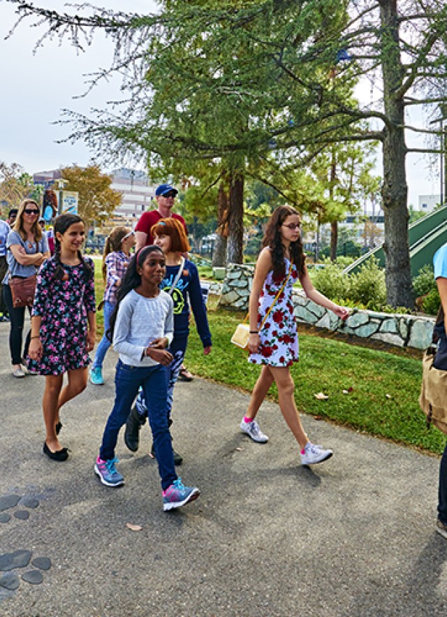 Museum Educator leading visitors along a path with big cat paw prints