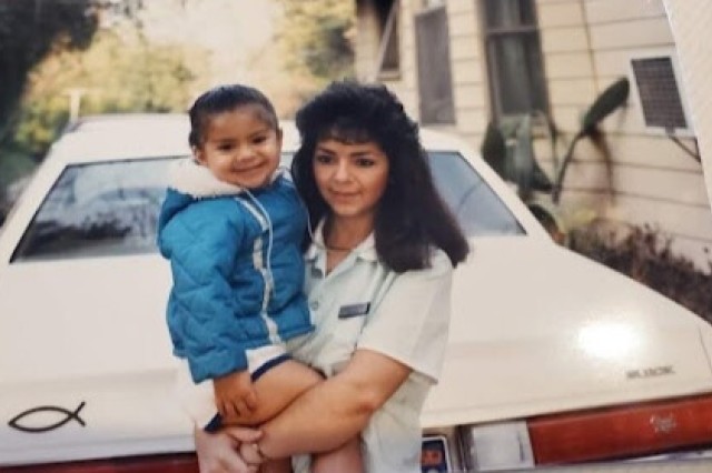 Baby Sandy Avila and her mom lean against the front of her mom's Regal.