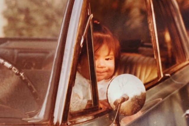 Baby Sandy Avila sitting in the drivers seat of her dad's lowrider.