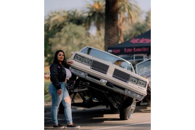 Sandy Avila with Simply Beautiful, her 1984 Oldsmobile, at car show.