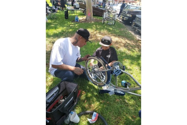 Sandy's husband and son working on lowrider bike together.