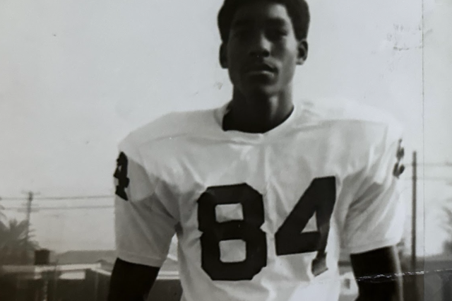 A young, determined Percell Keeling in a white football jersey featuring the number 84.